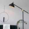 Industrijska podna lampa Steinhauer Mexlite Nové u mat crnoj boji sa zlatnom unutrašnjošću abažura pored radnog stola