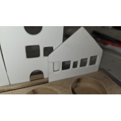 Beli porcelanski gradić na postolju od drveta bagrema sa upaljenim svećama popravljeno